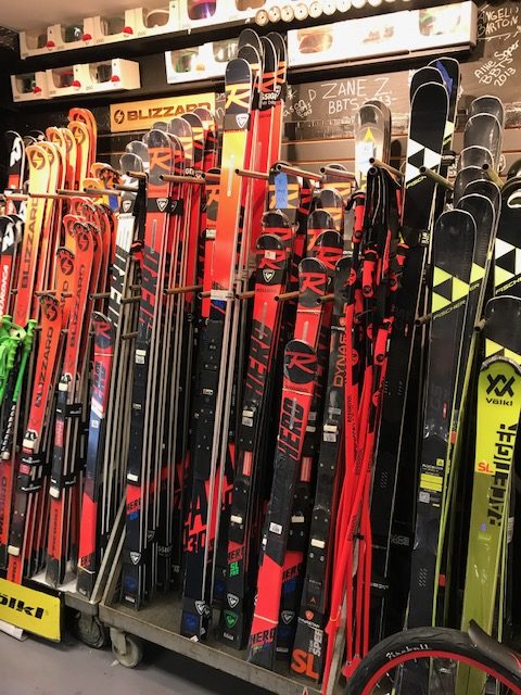 several new race skis on a rack